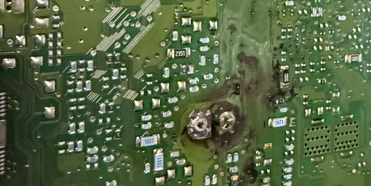 Burned circuit board inside a Genesis 4.6 engine control module, West Palm Beach electronic laboratory.